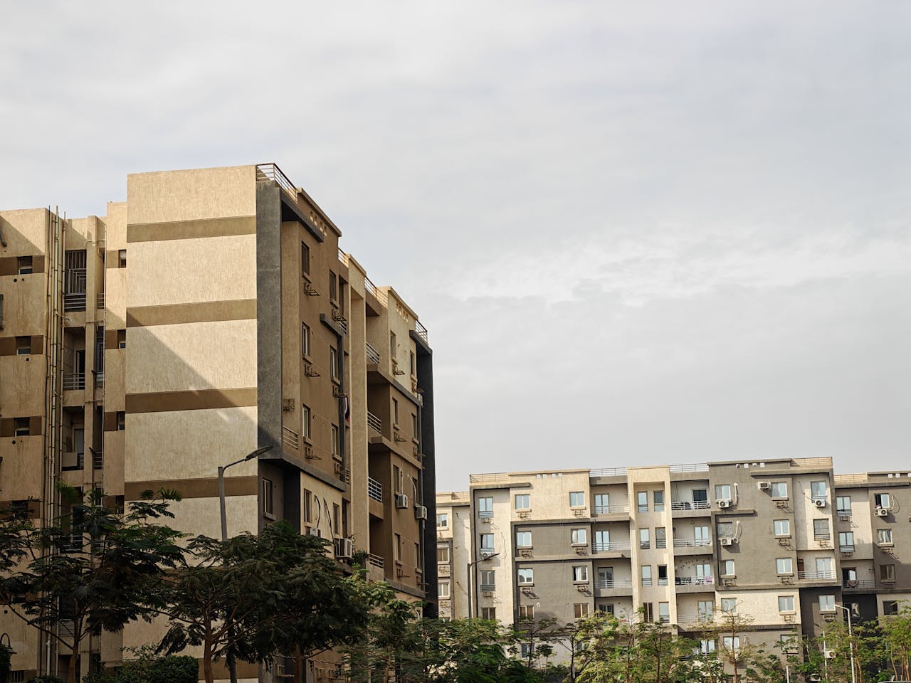 Capture of modern apartment buildings with a cloudy sky background, showcasing urban architecture.