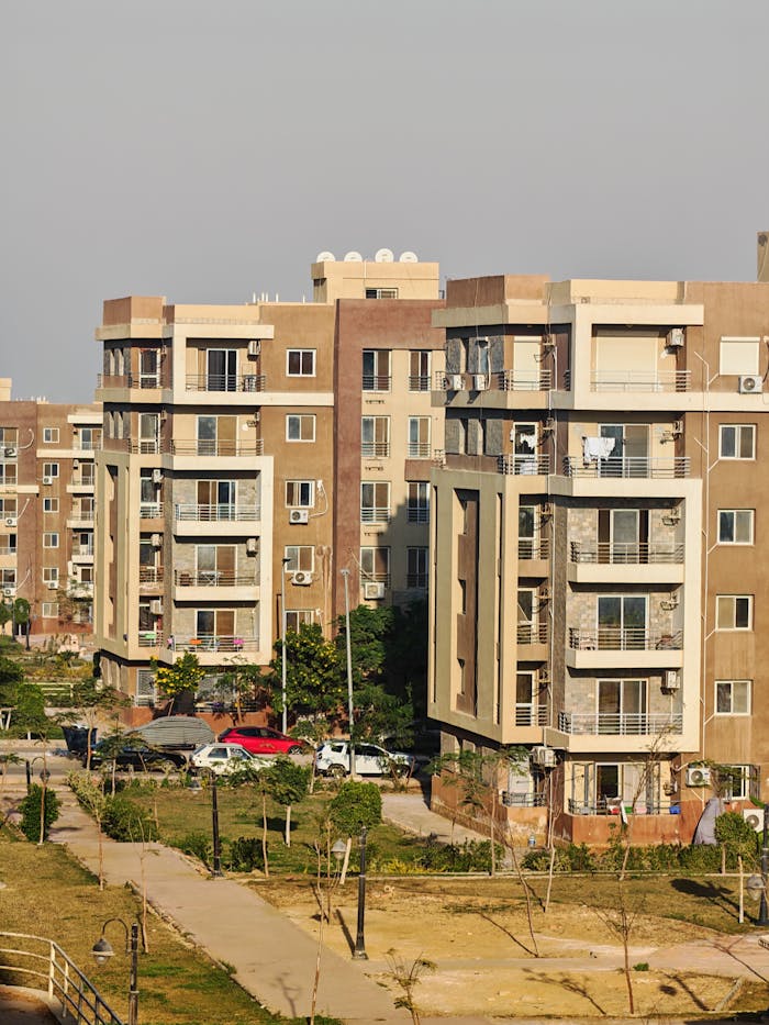 Outdoor view of a modern residential apartment complex with multiple buildings under clear sky.