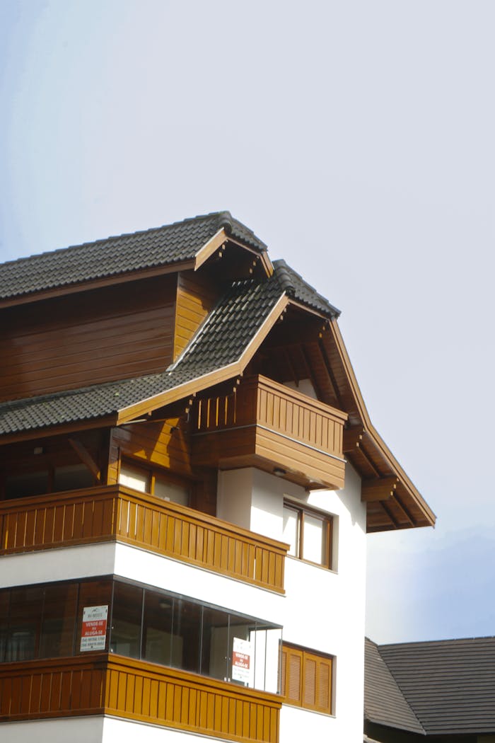 Close-up view of a picturesque European chalet featuring traditional wooden and white architecture under a clear sky.